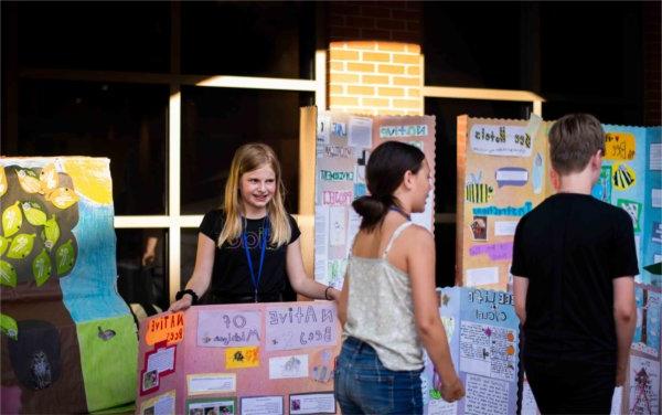 Maria Ochoa, right, 5月15日，在皮尤大急流城校园举行的Groundswell管理倡议学生项目展示会上，蒙台梭利学生项目附近.